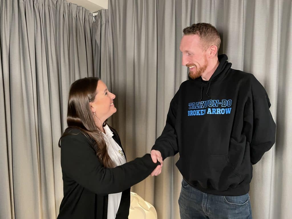 TEDC Loan Closings and Compliance Manager Joanna Oxford shakes hands with Kristoffer Morrison as they close on his SBA Microloan