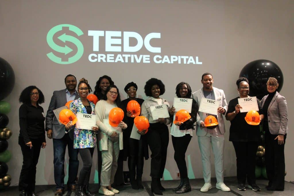 reBUILD cohort 3 hold up their certificates and pose with TEDC CEO and EDEN director.