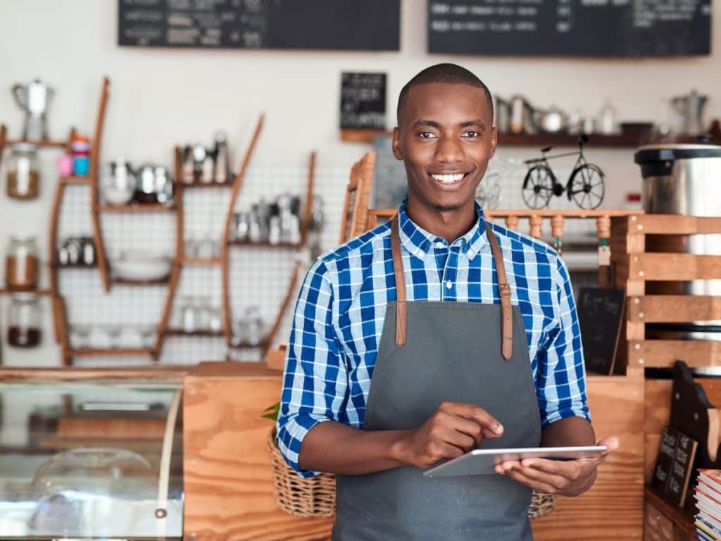 Small business owner smiling and holding a tablet