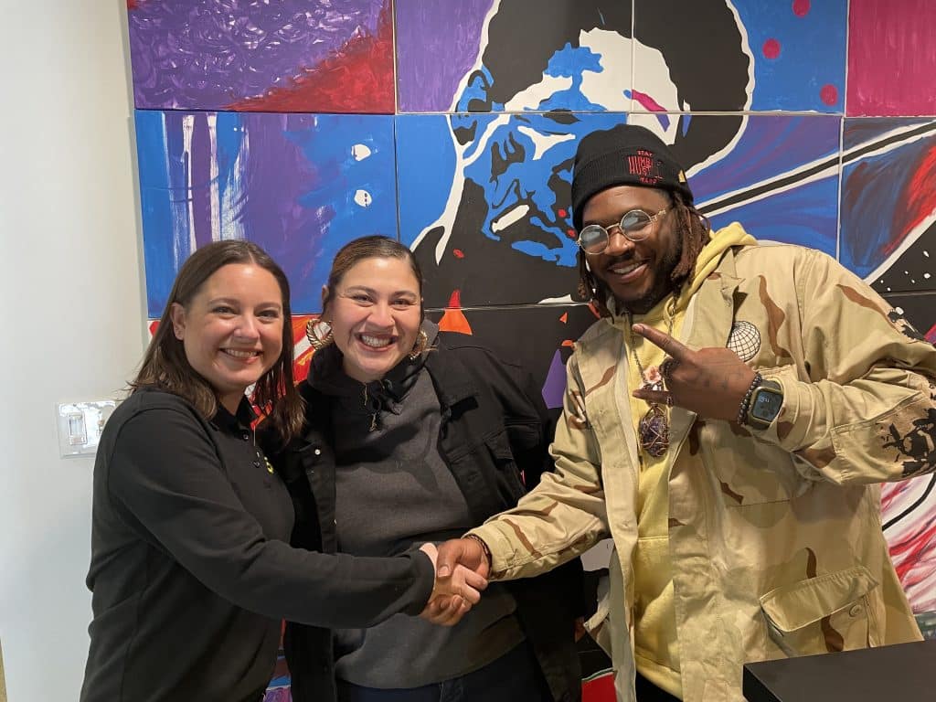 Joanna Oxford shaking hands with Leroux’s Kitchen owners
