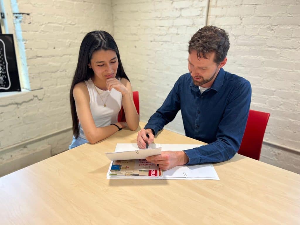 Quick-Business-Loans-TEDC Two people sitting at a desk signing a business loan