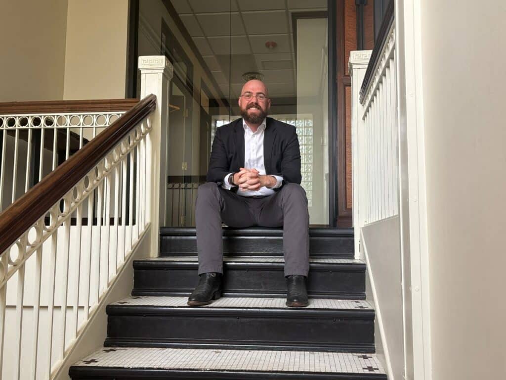 Ray Fitzgerald sitting on stairs smiling