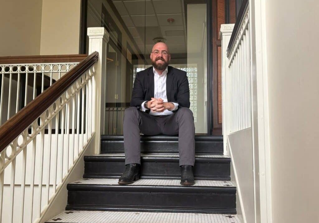 Ray Fitzgerald sitting on stairs smiling